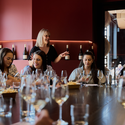 Member of staff conducting a tasting with a group of people in private room